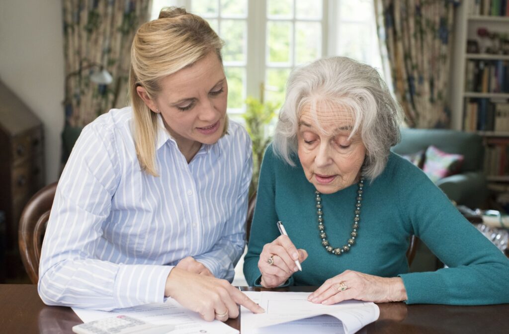 a caregiver helping a senior woman read in home healthcare