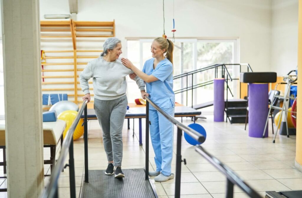 a senior getting help for walking from a caregiver in rehabilitation