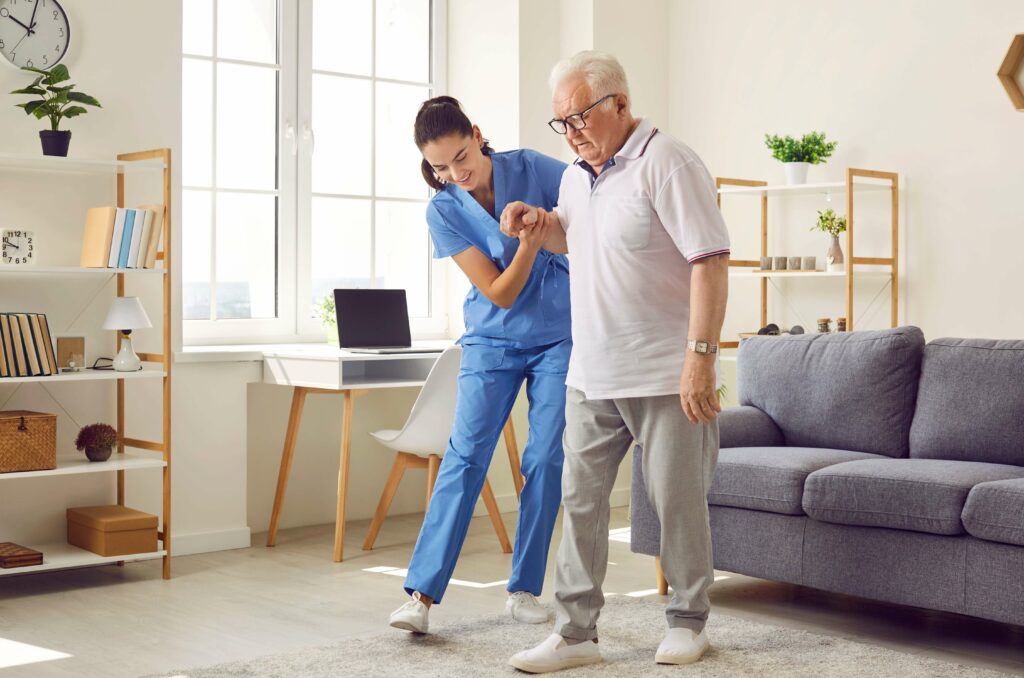 A home healthcare worker supports a senior lifting light dumbbell weights during rehabilitation following hospitalization
